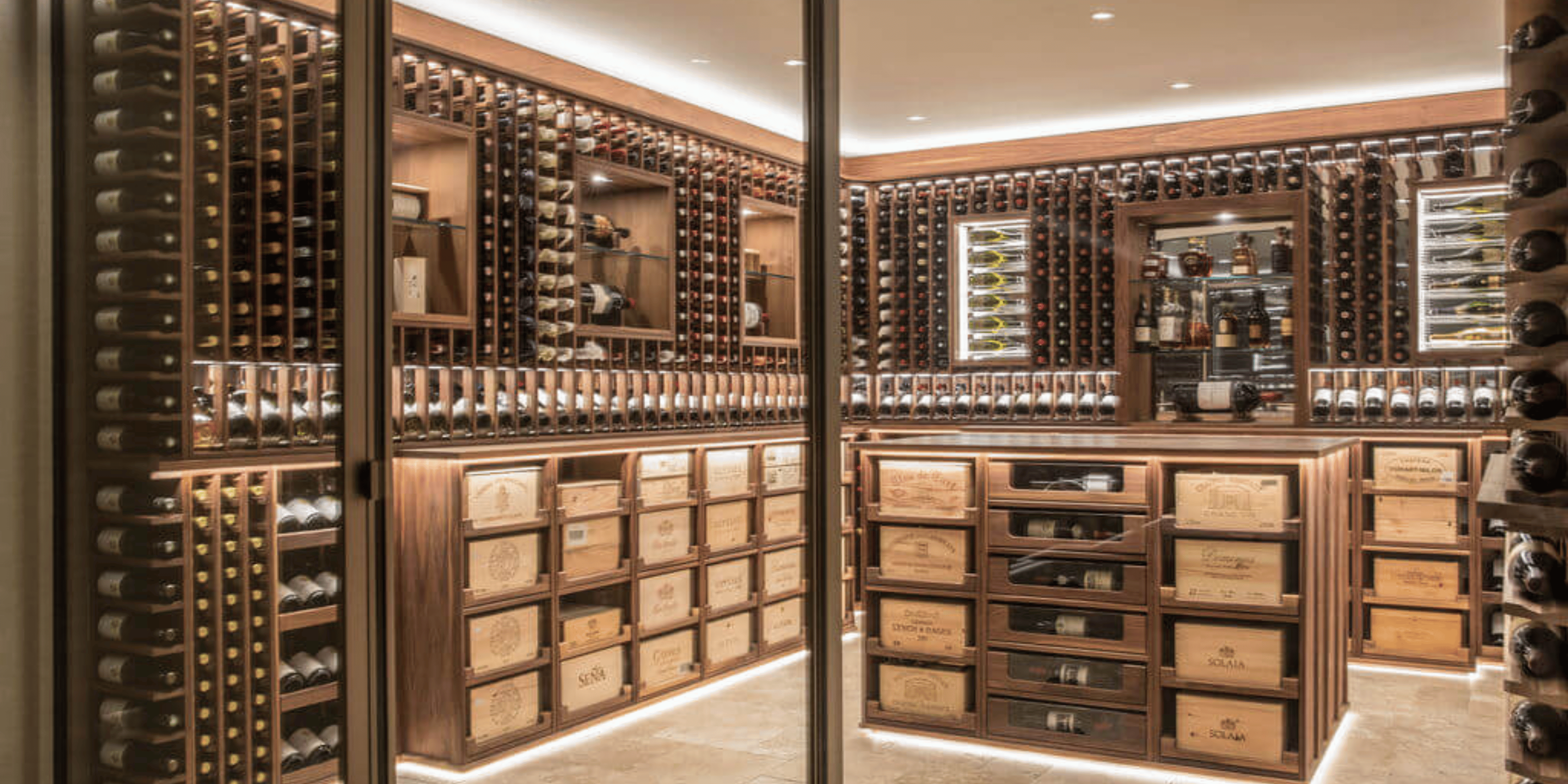 An oiled walnut wine cellar, located within a private property in Basil, Switzerland. The fine wine cellar houses thousands of bottles, both in cases and individual, as well as spirits.