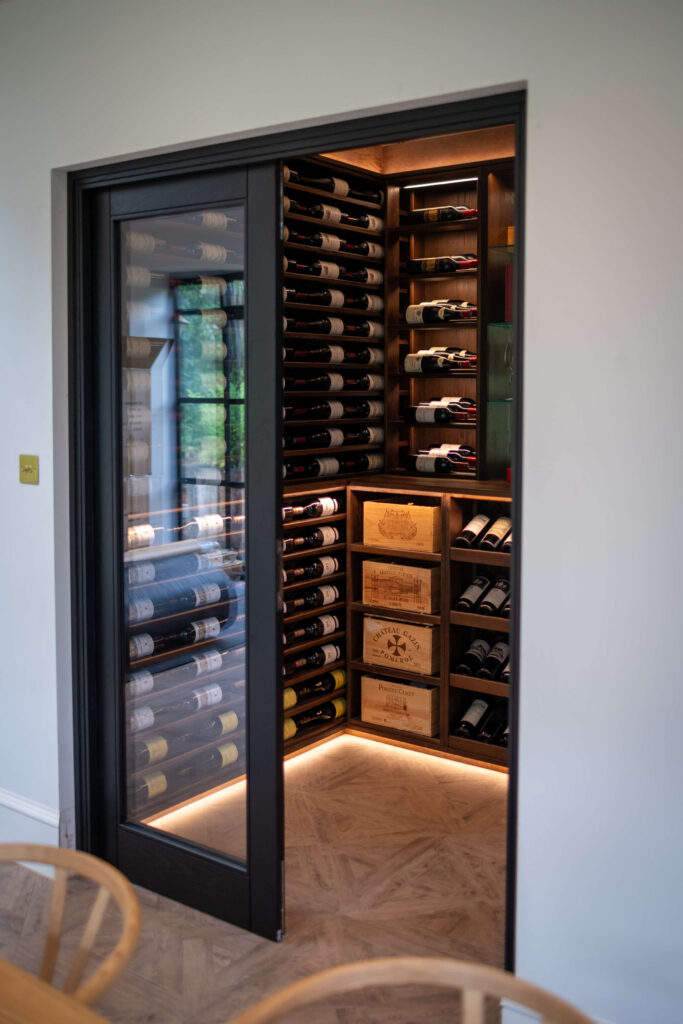 A door open into a Sorrells wine room. The open door offers a view into the wine cellar housing hundreds of bottles.