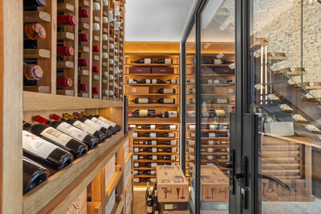 a wall of wine racks with metal framework and glass doors