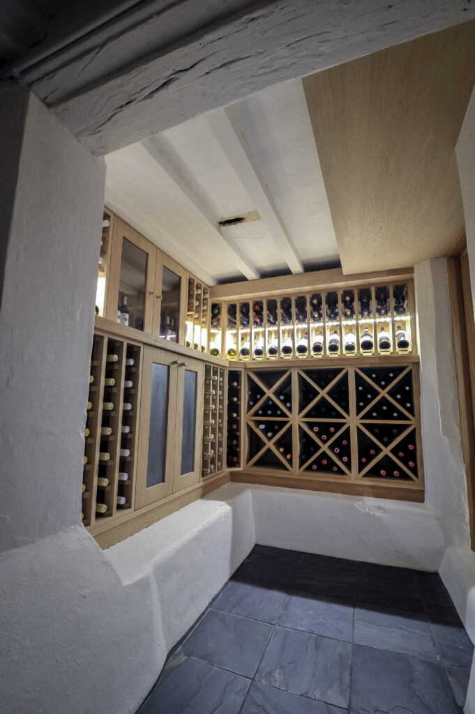 Bespoke light oak wine cellar built around original brickwork