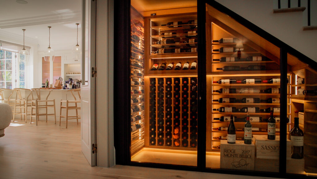 a close up of a dimly lit wine cellar located under a staircase