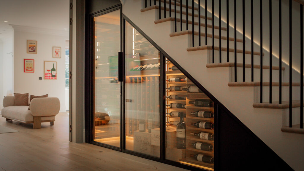 an understairs wine cellar with black frame and oak racking