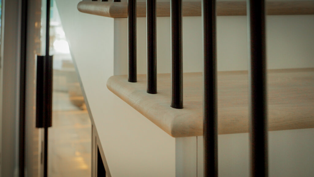 the spindles of a staircase with an out of focus wine cellar in the background